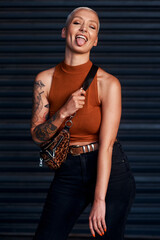 Hey there silly. Cropped shot of an attractive young woman sticking out her tongue while standing against a dark background.