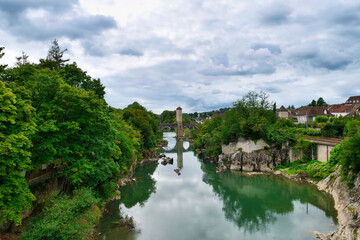 Fototapeta na wymiar River L'Adour in the city of Orthez, with bridge with a tower in the center