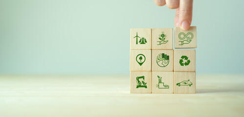 Circular economy concept. Business and environment sustainable. Climate changing problem solving goals..Stacking wooden cube with eco infinity and environment sustainable symbols on smart backgound - obrazy, fototapety, plakaty