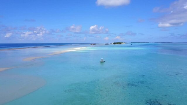 Ocean, tropical island and fishing boad in the middle of the ocean. Aerial shot. Holidays in paradise concept. Maldives