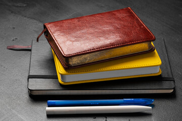 Three notepads on a black table close up