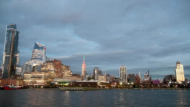 Midtown Manhattan and Hudson Yards lights. Sunset view of modern skyscrapers in New York City from the Hudson River