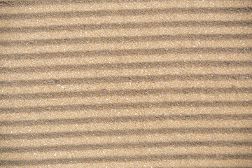 Small sized ripples formed in the sand on the beach