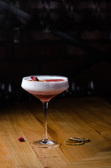Alcoholic cocktail of pink color with a rose, close-up. Modern alcoholic drink