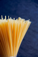 Yellow long spaghetti on a rustic background. Yellow italian pasta. Long spaghetti. Raw spaghetti bolognese. Raw spaghetti. Food background concept. Italian food and menu concept.