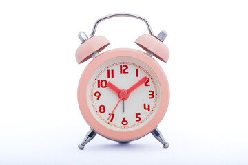 Pink color alarm clock isolated over white background.