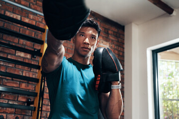 Naklejka premium Hes in a training mood today. Cropped shot of a handsome young male boxer working out in a gym.