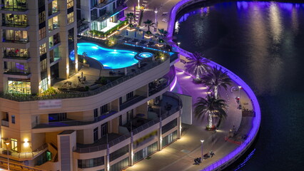 Dubai Marina waterfront and city promenade night timelapse from above.