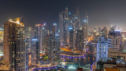 Naklejka premium View of various skyscrapers in tallest recidential block in Dubai Marina aerial night timelapse