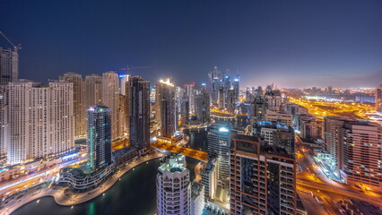 Naklejka premium Panorama of various skyscrapers in tallest recidential block in Dubai Marina aerial night to day timelapse