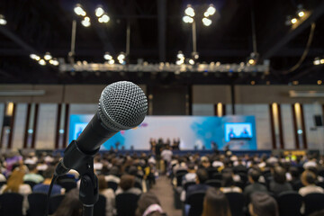 Microphone with Abstract blurred photo of conference hall or meeting room with attendee background,...