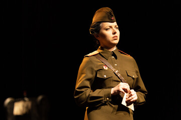 Actress in military uniforms of the Soviet army of World War II play a performance on stage in the...