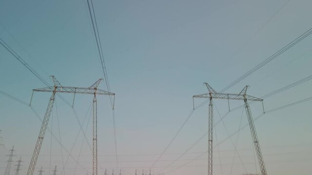 Power pylons in a field in winter. High voltage wires on metal poles. The concept of electrification of remote areas.