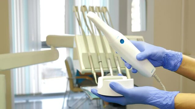 Manual 3D scanner for teeth in hands. New technologies in dentistry. Modern dental clinic equipment. Orthodontist using 3D intraoral scanner for scanning patient teeth. 4 k video