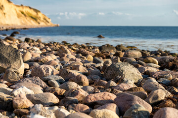 Fototapeta na wymiar Steiniger Strand an der dänischen Ostseeküste mit Steilhang im Hintergrund