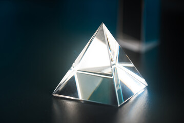 Luminous triangular prism on the table. Prism in the shape of a pyramid