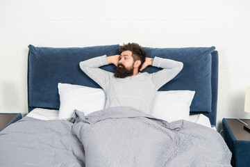 Obraz premium Drowsy guy being in bed awake after sleep, morning