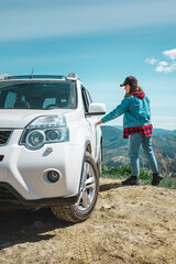 women sitting in suv car at the mountain peak