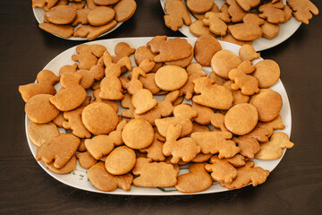 Handmade Easter gingerbread cookies in white plate on dark table.Spring symbols made from gingerbread.Homemade cookies.Easter bunny,rabbit,eggs and ducks from delicious honey dough.Happy Easter.