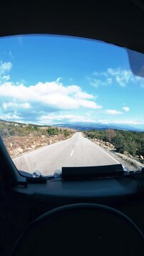 Point of view of camper van driving on road against cloudy sky