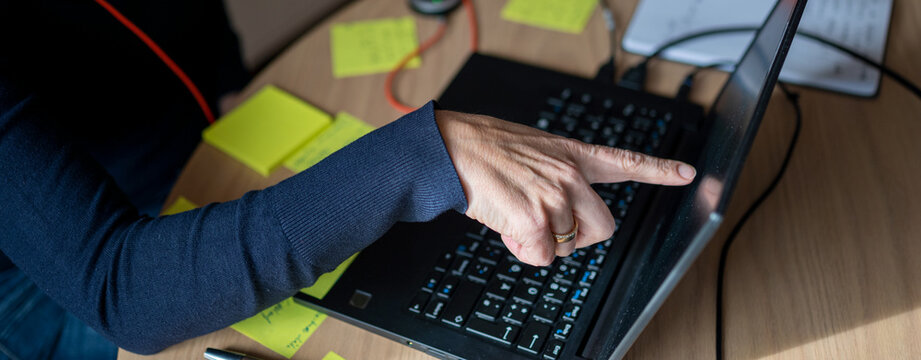 Frau zeig mit ihrem Finger auf Laptop Bildschirm Mockup