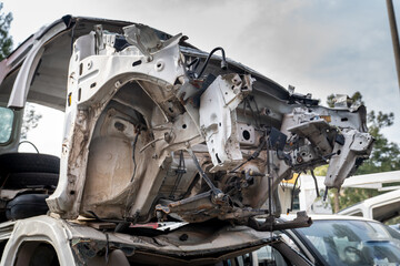 Metal scrapped rusty car body parts abandoned. Car dump awaits recycling in junkyard.