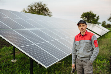 Portrait of an electrician engineer, on a background of solar panels. The future of alternative energy and sustainable energy.