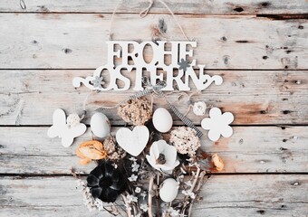 easter card - eggs with flowers on a wooden background and German text - Happy Easter