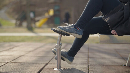 Person spinning bike pedals on outdoor gym equipment close-up