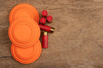 Flying clay pigeon target with shot gun bullet shell on wooden background , Gun shooting game