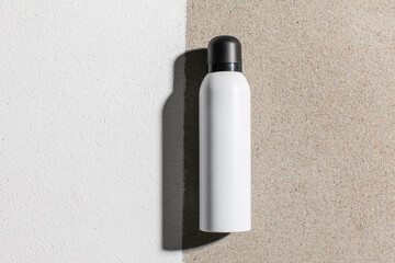 Flat lay top view mockup of white plastic aerosol tube with deodorant, hairspray or other cosmetics on background with deep shadows. Concept bio organic beauty products