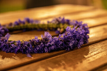 Selective focus shot of purple flower crown on wooden table