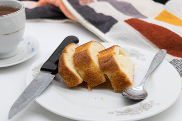 slices of pound cake in a plate in white background with a cup of tea