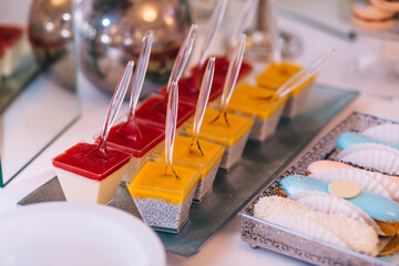candy bar, pastries and almond eclairs are spread out on beautiful trays.