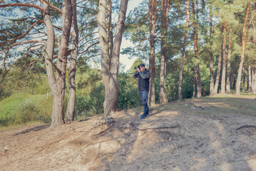 Obraz premium Man nature photographer taking pictures in the forest.