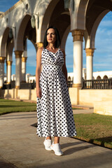 Happy young woman walking on hotel territory. Summer vacation in Egypt. Stylish fashionable look