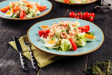 Closeup on fresh caesar salad with shrimp sprinkled with parmesan