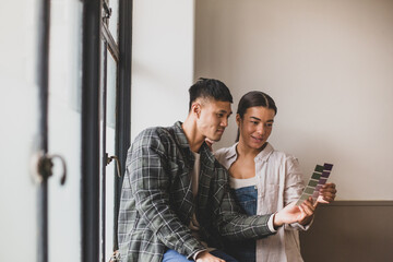 Mid adult couple choosing wall paint colours