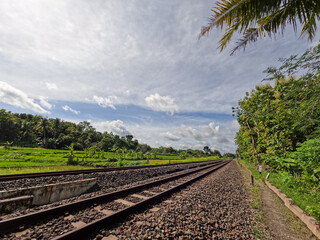 Fototapeta premium The view of the rail road in Yogyakarta Indonesia, visible rocks and a clear sky background