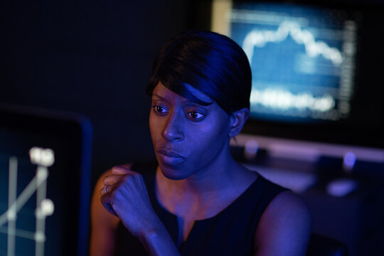 Female stockbroker working late at night trading