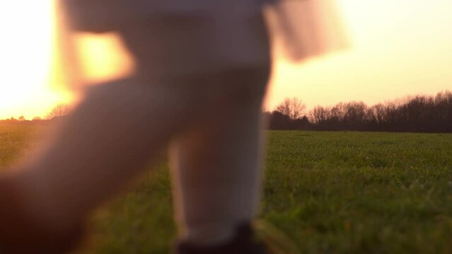Happy family at sunset. Silhouette of group of people walk in park. child with parents holding hand. Father playing football game on grass. Young Dad fave fun do sport with children siblings outside