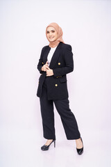 Full length portrait of a beautiful Muslim female model wearing stylish black office attire with hijab isolated over white studio background. Fashion, beauty, corporate, lifestyle concept. 