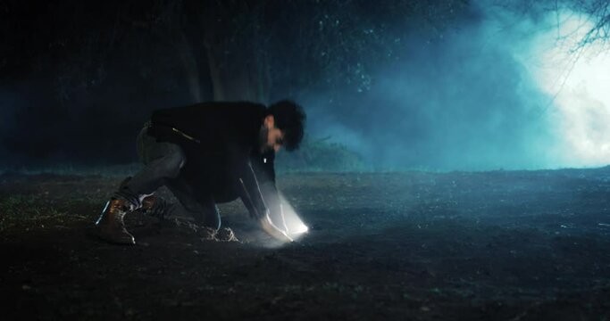 young boy searches for treasure at night in the woods