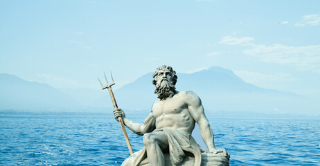 The mighty god of the sea and oceans Neptune (Poseidon) against sea and mountain landscape. The ancient statue. © zwiebackesser