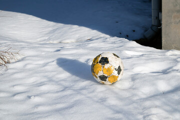 worn-out soccer ball on snow
