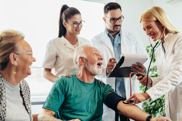 Group of young doctor during home visit senior people, control blood pressure.