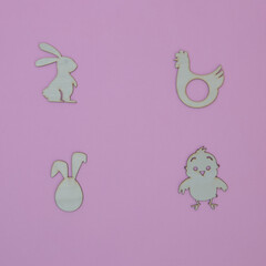 Easter symbols, rabbit, chicken, chicken, rabbit ears, on a pink background with copy space. Minimal flat lay scene.