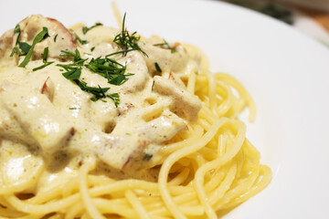 Pasta carbonara with cheese on a white plate
