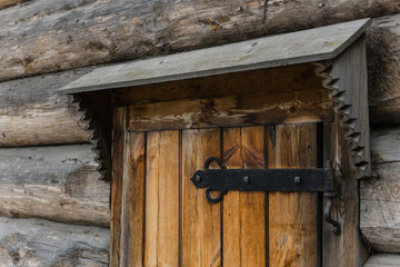 forged hinge on a wooden shutter and a carved visor. ancient Russian architecture