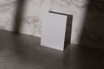 Blank empty mock up art paper sheet on marble granite with shadow
